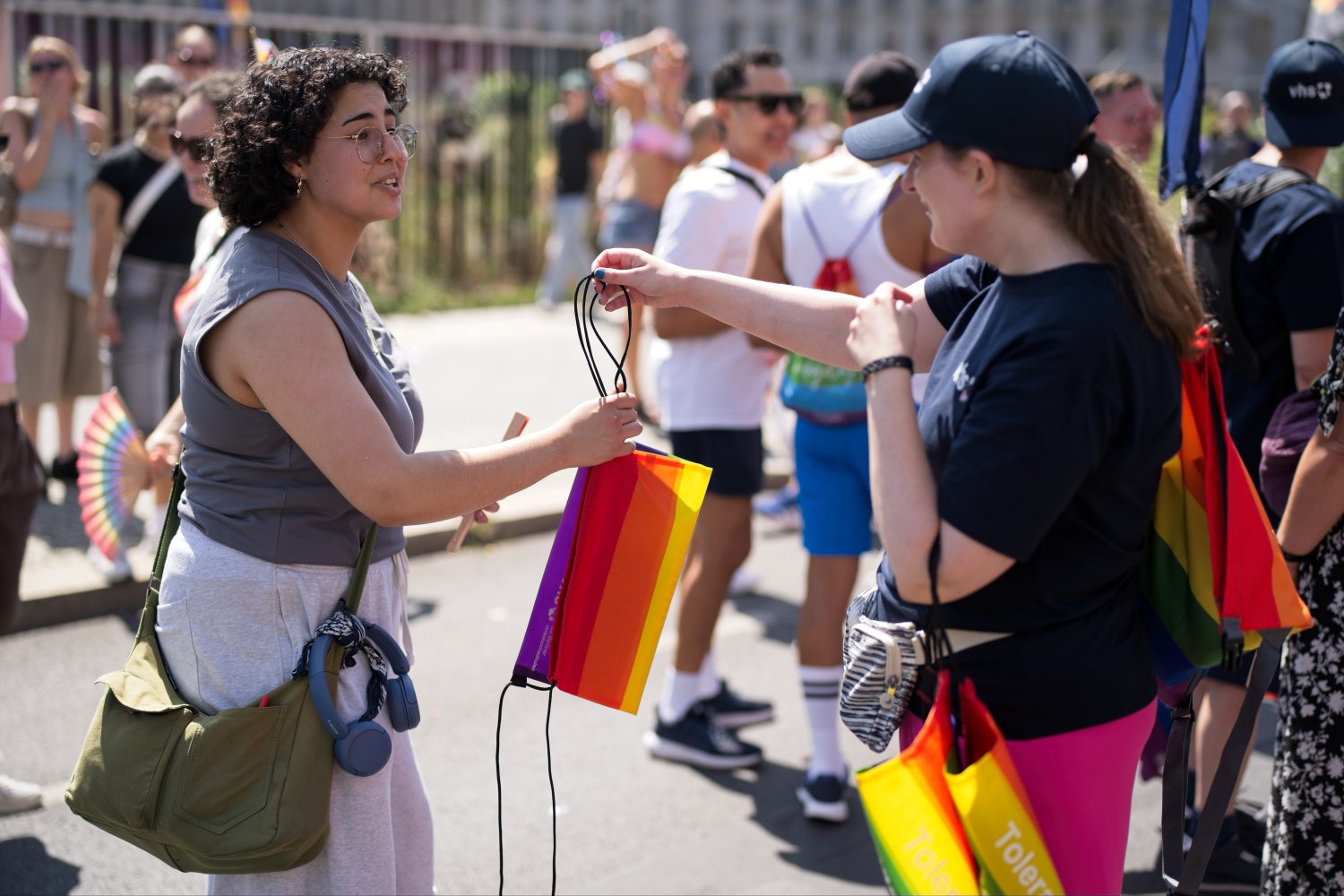 SerZ-Kollegin verteilt Regenbogenbeutel auf dem CSD